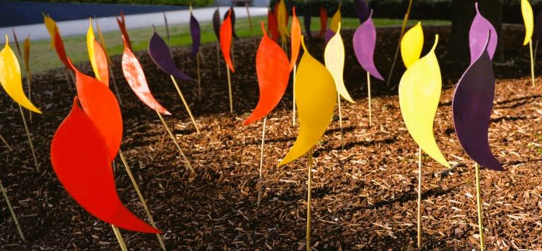 Artistic coloured leaf designs on stakes in ground