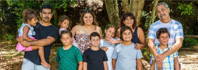 A lcommunity of Aboriginal people of all ages having a photo taken of them, looking at the camera