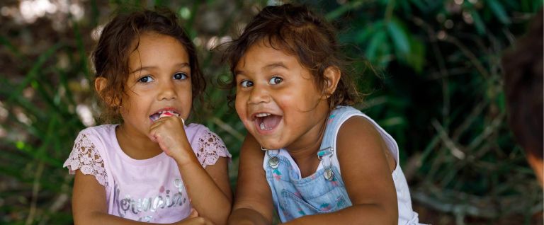 Two smiling Aboriginal girls looking at the camera