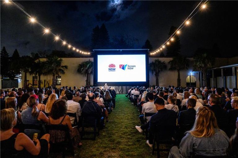 Image of audience watching a movie screen with the Screen NSW logo on it