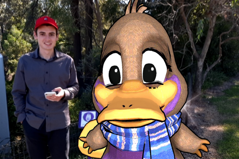 A member of the team behind the Muscle Creek Augmented Reality Tour poses with Pat the Platypus using the augmented reality platform.