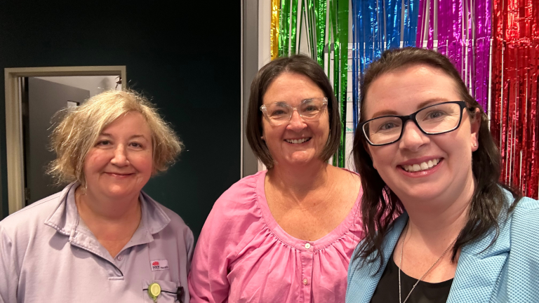 three SNSWLHD staff members standing in front of pride banner