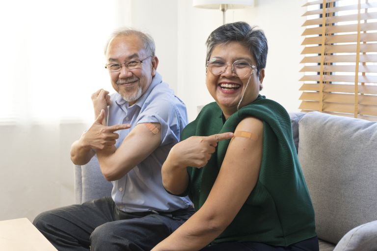 Seniors pointing to their arm after flu vaccine