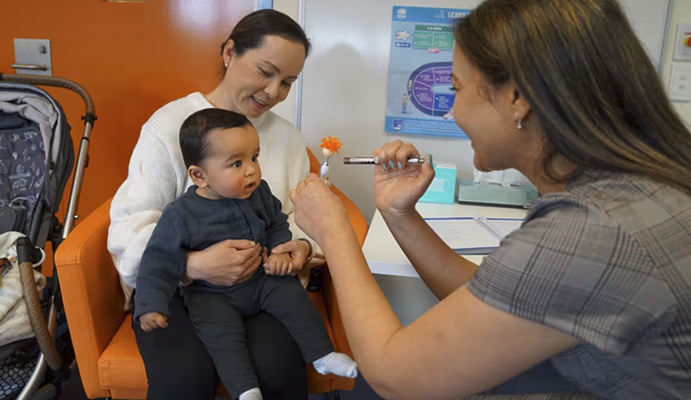 Mother and baby with nurse getting health check