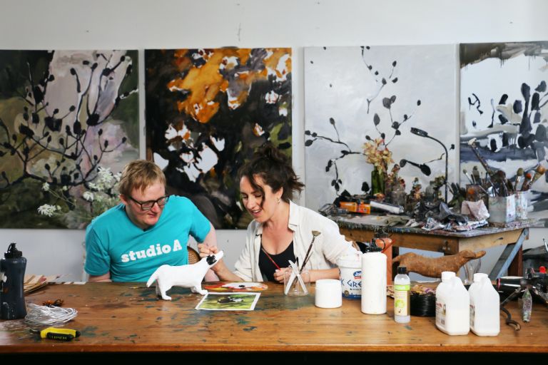 Two artists working in a studio painting