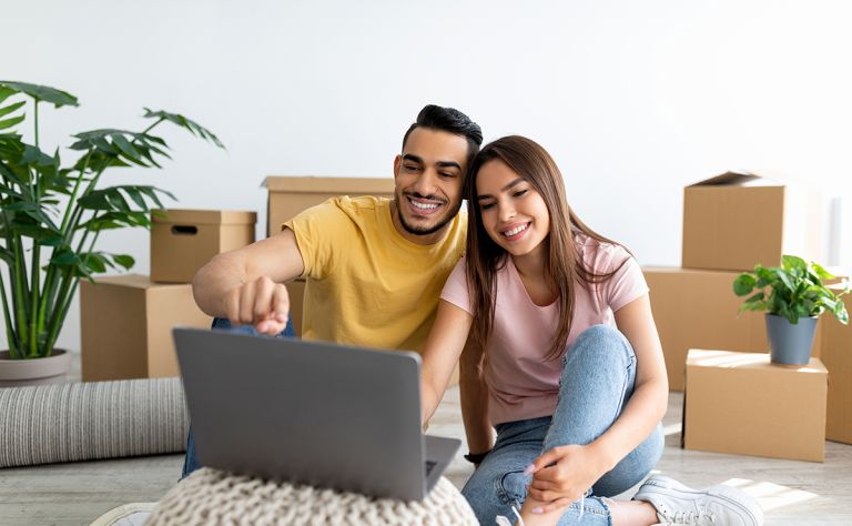 A man and woman in a rental property looking at a laptop