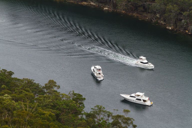 Three boats sail move past each other on a river.