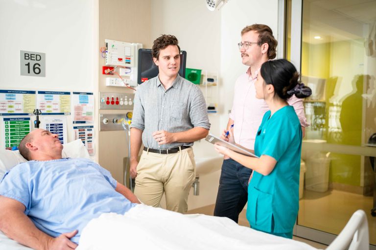 Allied health workers standing around a patient