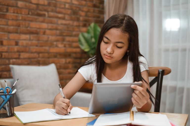 Stage 5 home schooled child writing at a desk