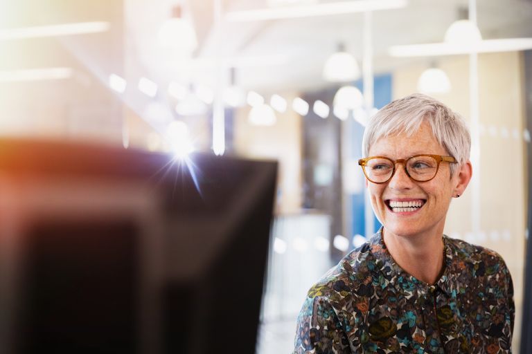 A smiling woman with glasses looking at the camera