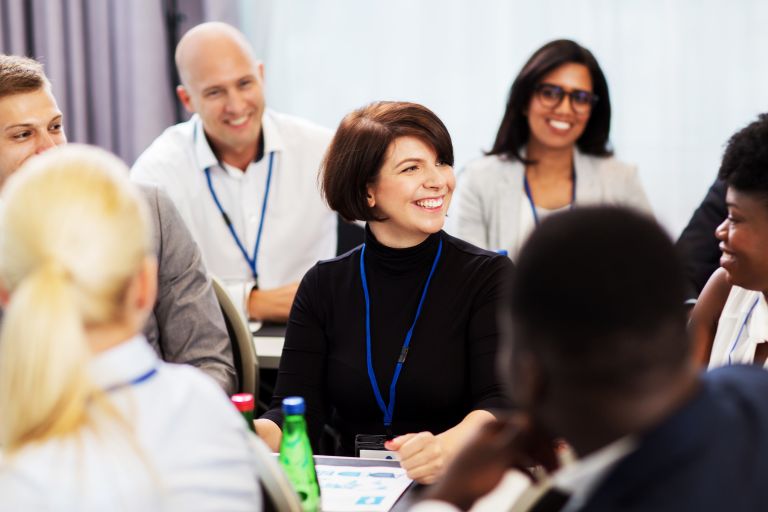 A diverse group of people gathered around a table, engaged in a meeting and discussing ideas together