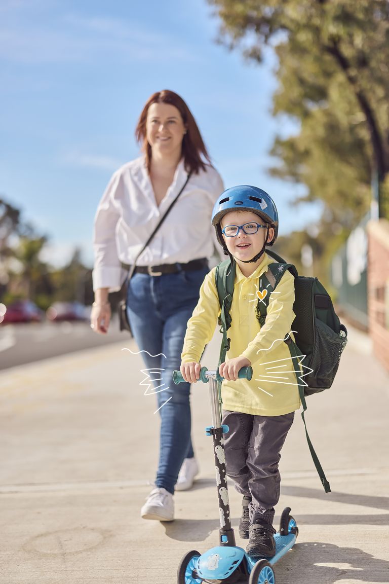 Young boy on scooter riding to school