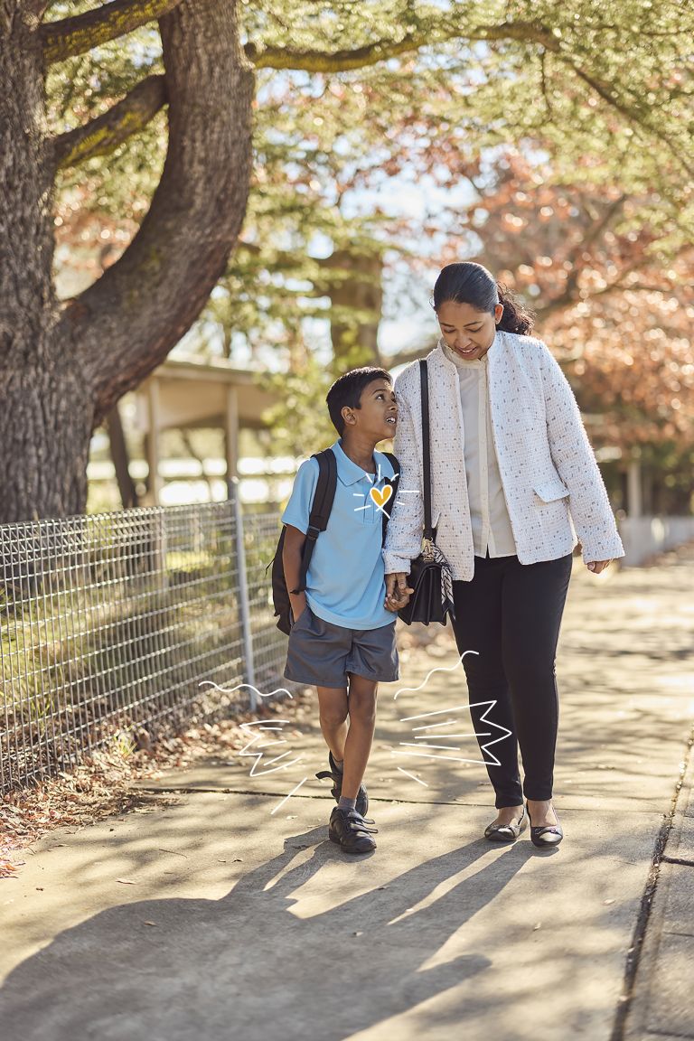 A boy walking to school with a parent