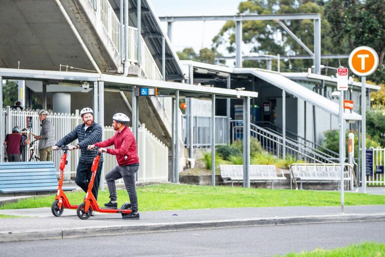 E-scooter riders at a train station