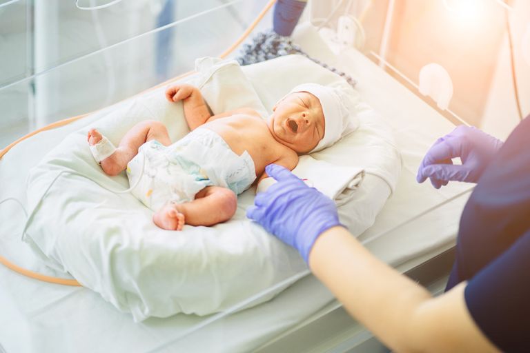 A nurse treating a baby in intensive care