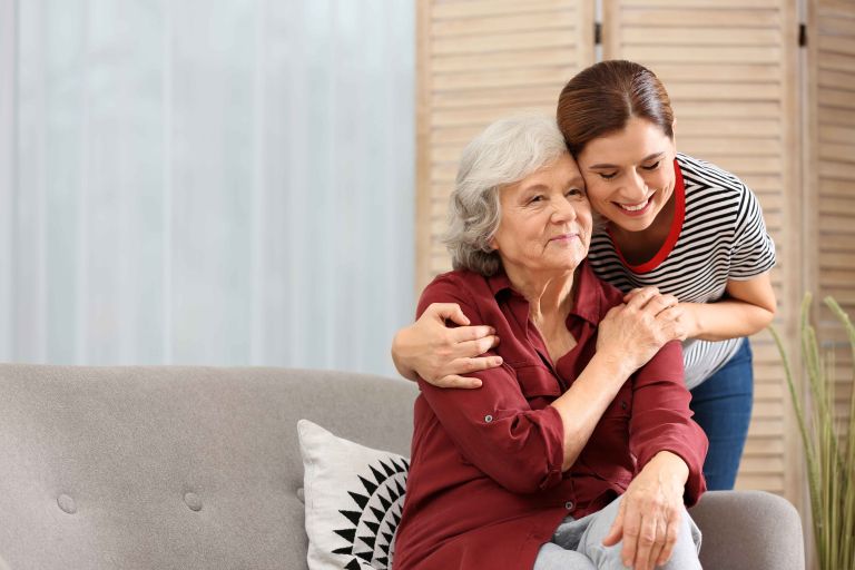 A young woman supporting an elderly lady 