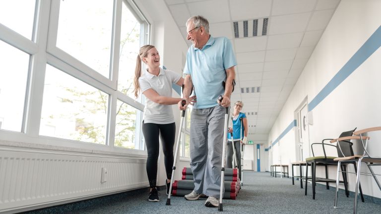 patient learning to walk with assistance from healthcare professional