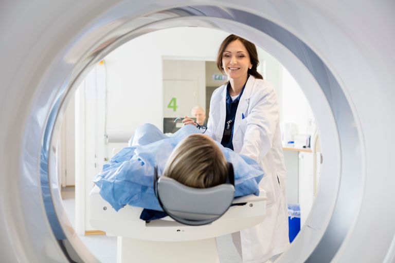 Healthcare professional preparing a patient for medical scans.