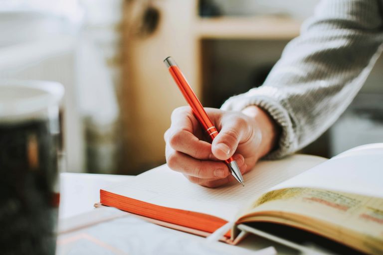 A hand writing in a journal