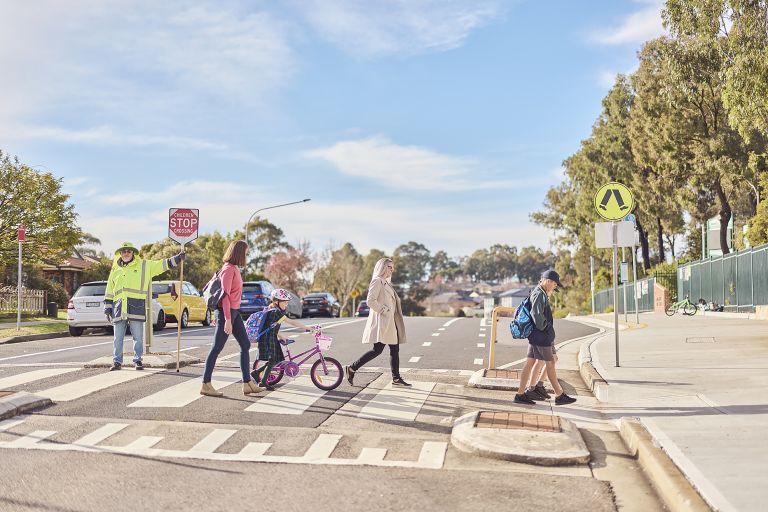 Parents crossing road in front of school