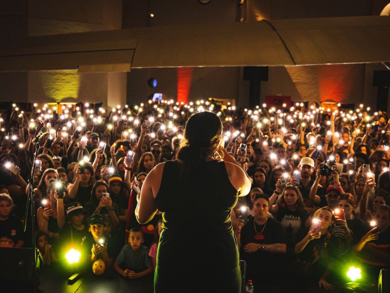 Woman performing in front of a large crowd