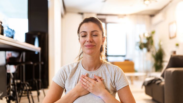 Woman holding her hands to her chest and looking relaxed