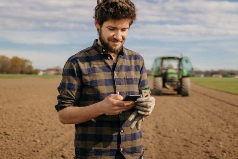 Male farmer on his phone in a field