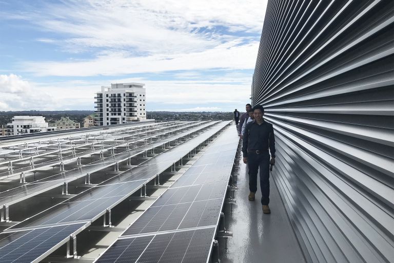 People inspecting rooftop solar panels.