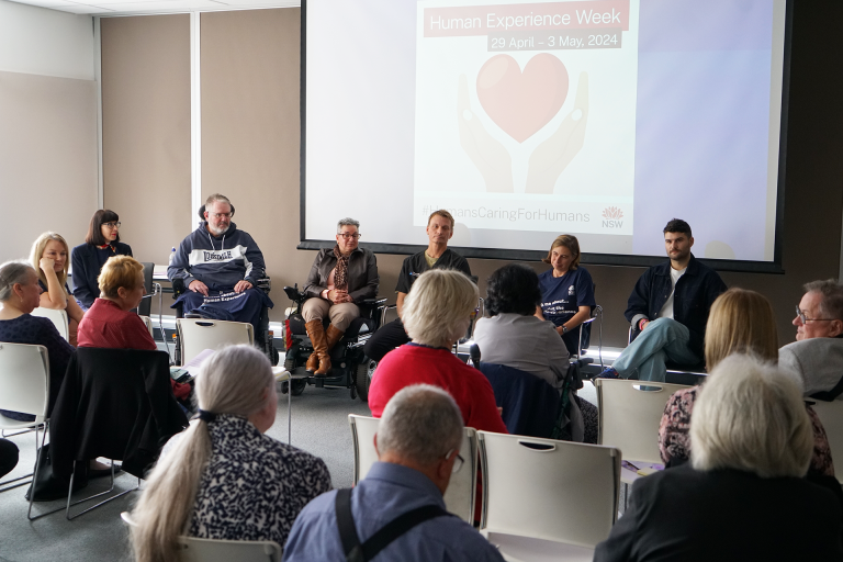 Individuals on an event panel with people in the audience