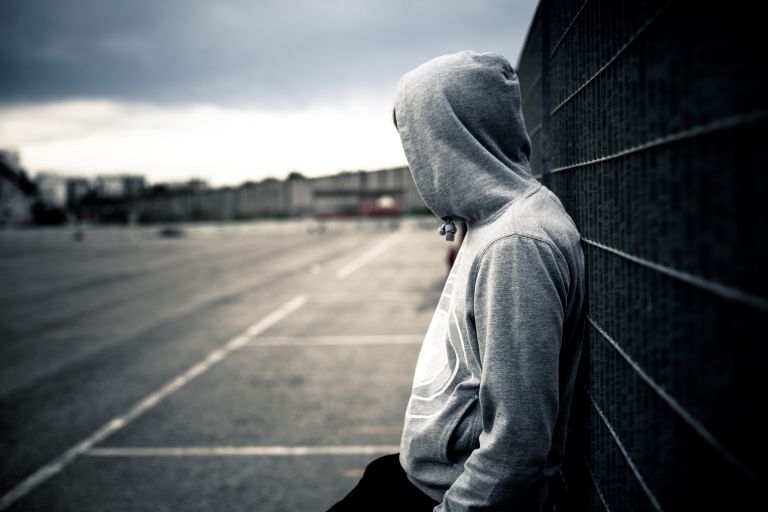 Teenage boy leaning against wall