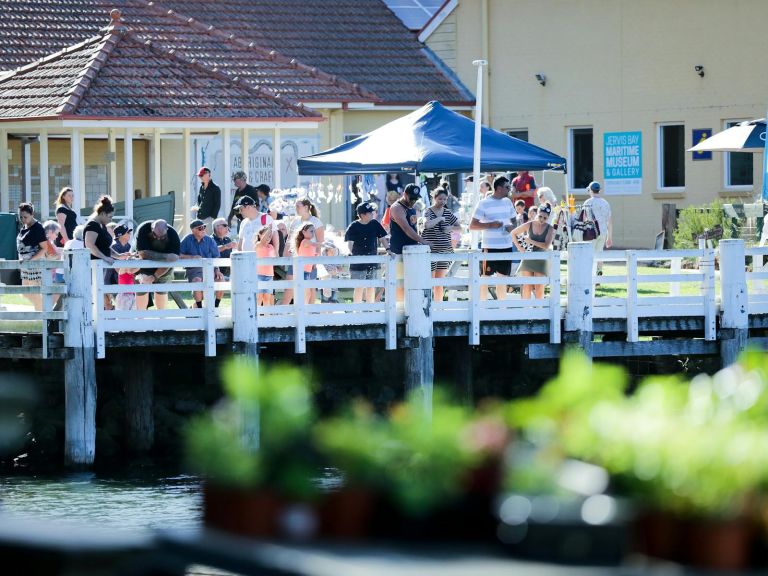 people gathered on wharf - including children and adults.