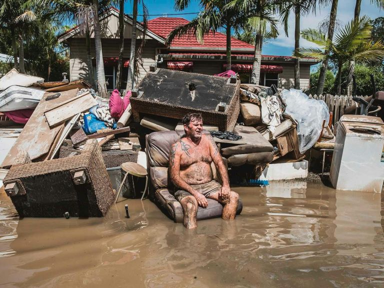 Peter sits outside his flooded Wardell home, alongside his discarded belongings, 6 April 2022. This