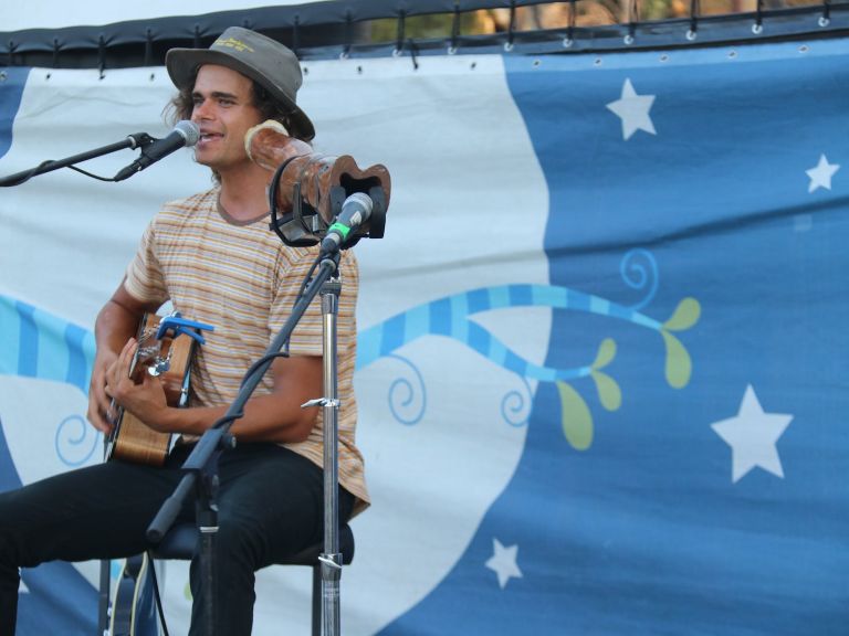 Musician singing on stage with guitar