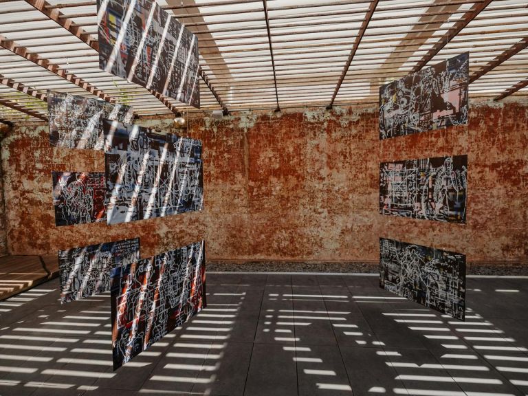 Paintings hanging from ceiling in a semi outdoor exercise yard of The Lock-Up