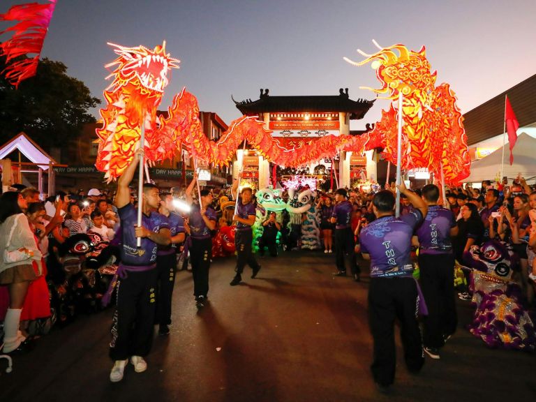 Lion dance performing in front of Pailau Gates with crowd in Freedom Plaza, Cabramatta