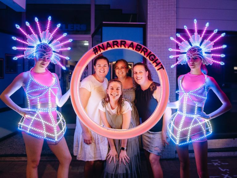 Visitors standing behind an light up sign of Narrabright