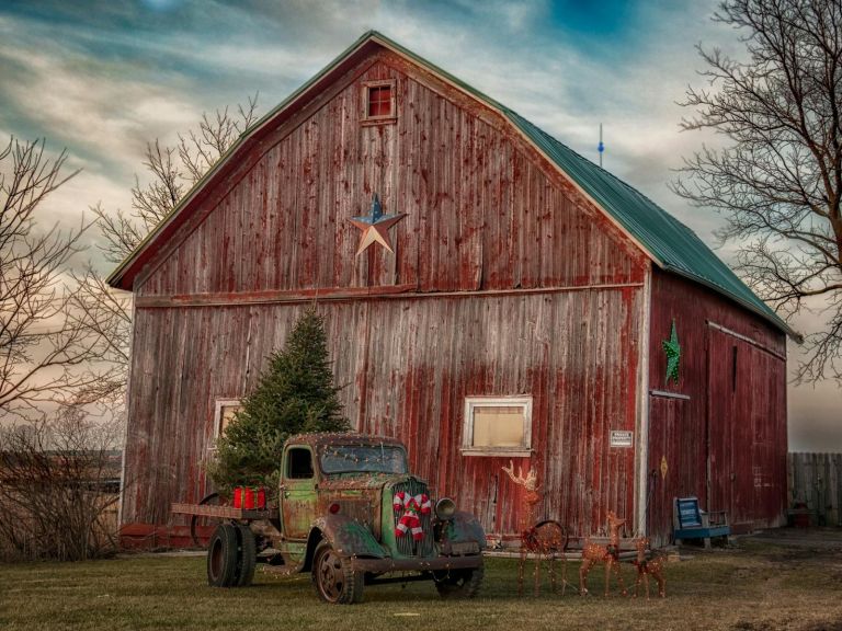 Barn at sundown with old car and Christmas Tree