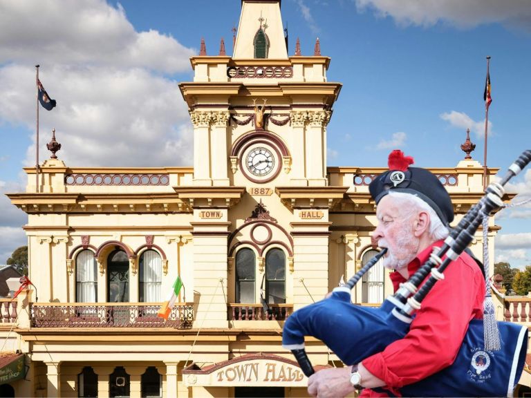 Lone Piper playing bagpipes with Glen Innes Town Hall in the background