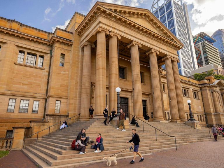 External of sandstone building with cityscape in background