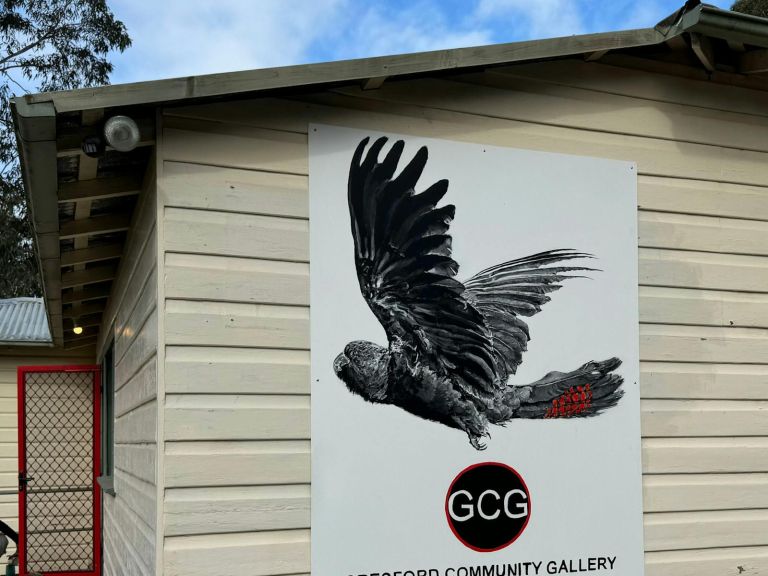 Large painting of Black Cockatoo on sign  with gallery logo and name.