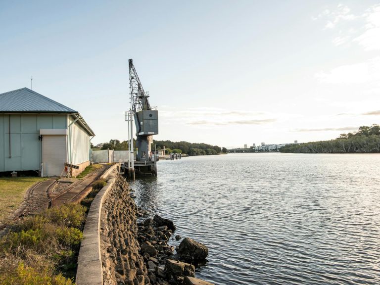 View of Parramatta River, on the edge is a heritage building and crane..