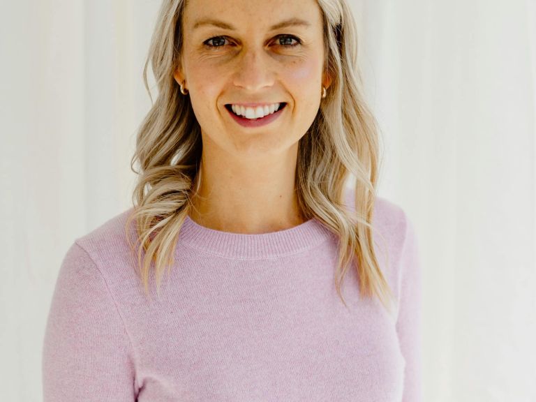 Smiling young lady with medium length blonde hair and mauve top