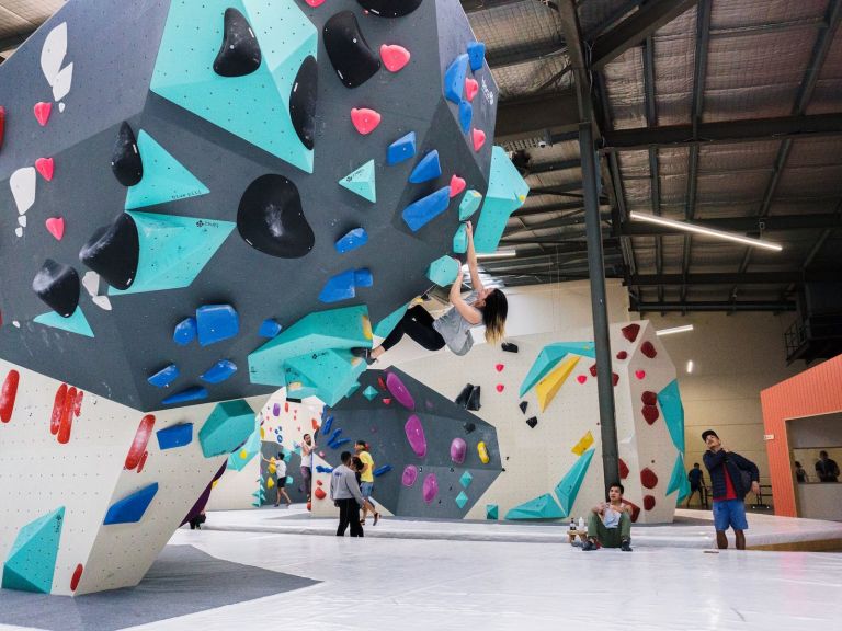 a climber is climbing on an overhung wall