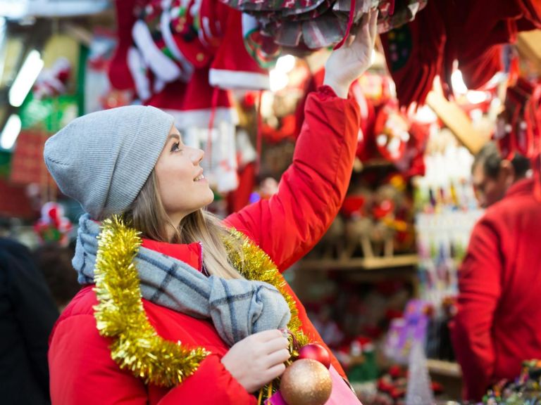 A woman shopping at a Christmas-themed stall.