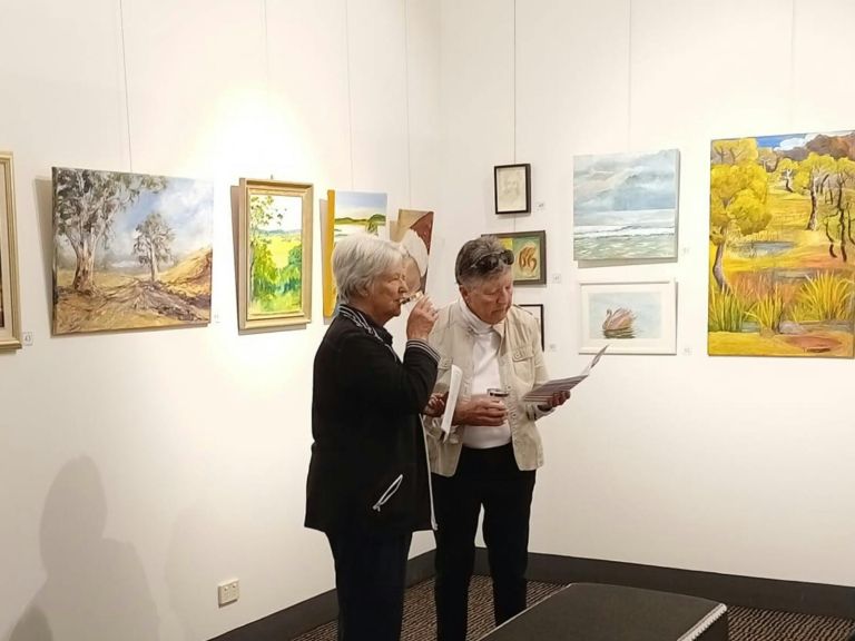 Two ladies browsing catalogue at Glen Innes Art Gallery