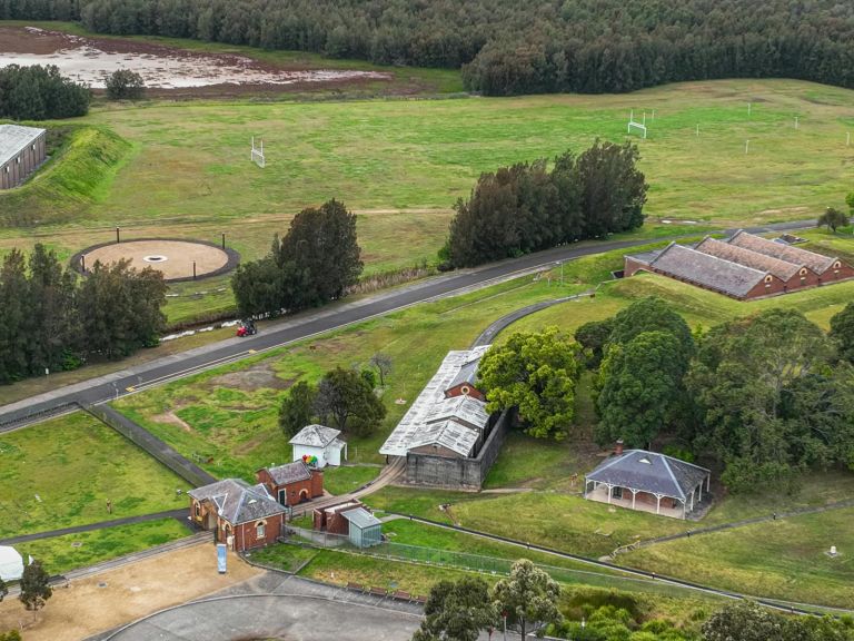 Birds eye, drone photo view of multiple heritage buildings and grass landscape.