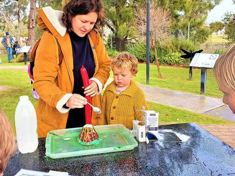 Mother and child adding bi-carb to model volcano