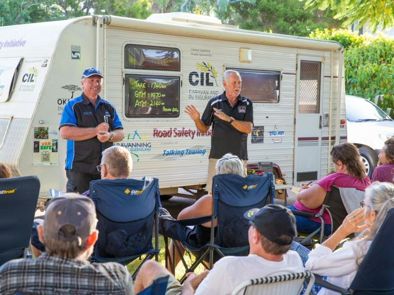 men in front of caravan at workshop