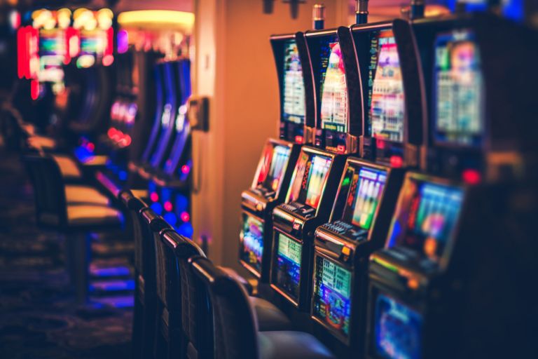 Rows of poker machines in the interior of a room.