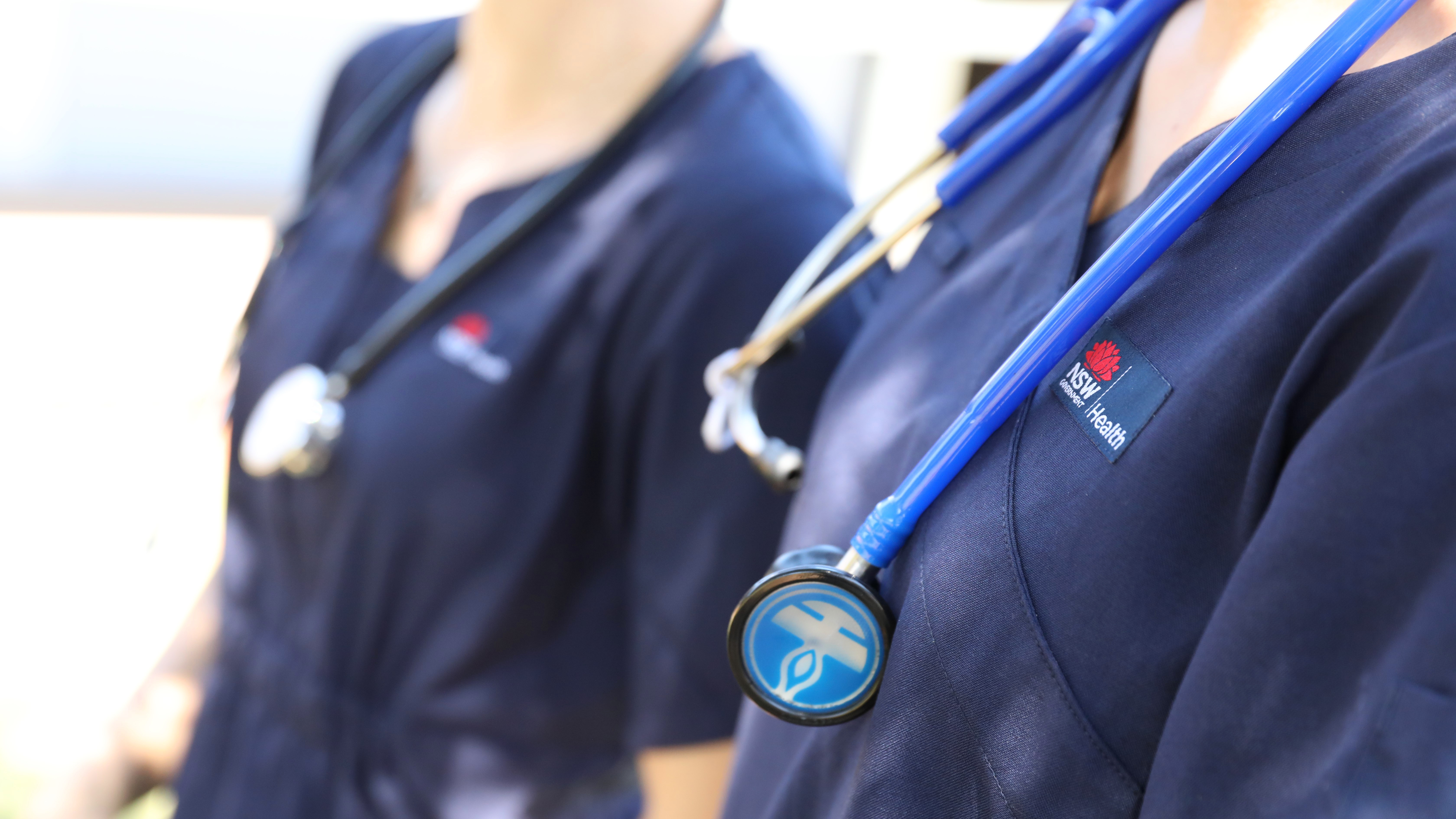 Two NSW Health workers in uniform.